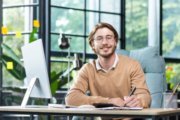Portrait of successful financier at work at workplace inside office, mature man smiling and looking at camera, businessman in shirt working with documents graphs and charts, paperwork using laptop