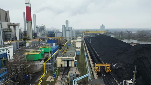 Environmental issues, energy extraction from coal, termal power station, view from height of the pipes in the smog, aerial view of the coal storage.