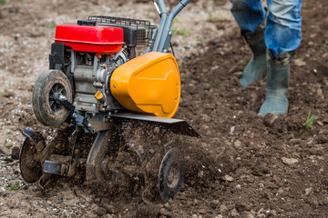 Banner. Man Farmer plows the land with a cultivator. Agricultural machinery: cultivator for tillage...