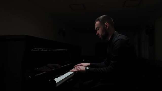 Playing the piano in a dark hall. Emotional piano playing