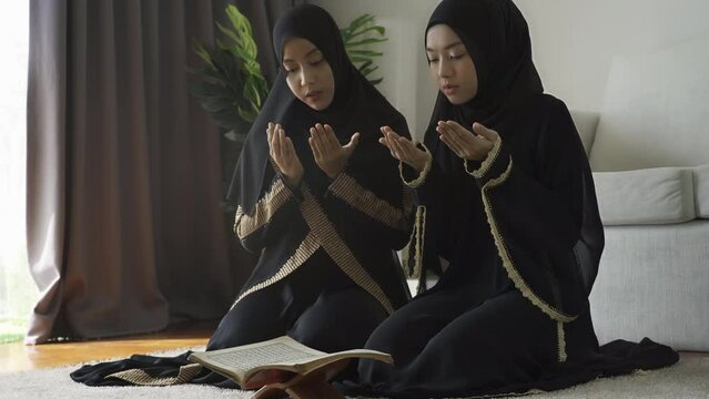 An Asian Muslim women reciting Salah or Salat al-Fatiha passage of the Qur'an, in a single act of sujud called a sajdah or prostrations at home