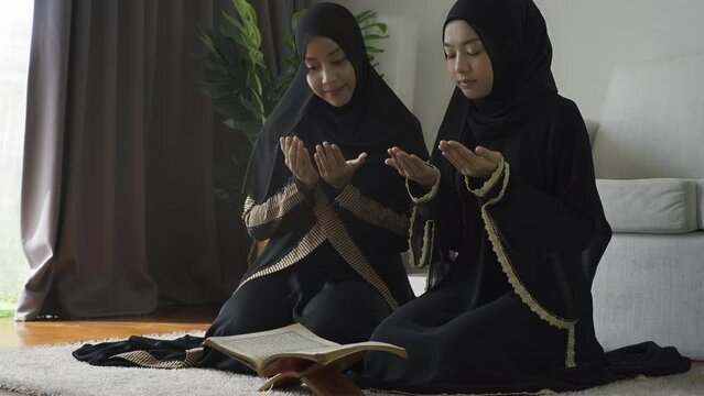 An Asian Muslim women reciting Salah or Salat al-Fatiha passage of the Qur'an, in a single act of sujud called a sajdah or prostrations at home