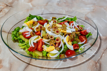 Salad with cherry, eggs, potatoes, onion, green olives with olive oil