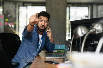 Portrait of young angry man in office.