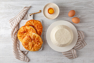Homemade whey ricotta cheese or cottage cheese and puff pastry ready to eat. Cooking process. Vegetarian healthy, nutritious diet food on a light background