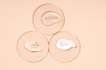 Cosmetic background, smears of cream on glass, texture of cream on a pastel beige background.