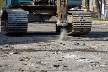 Pneumatic rock drill on bulldozer removes asphalt surface