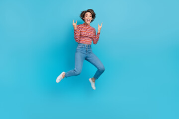 Fototapeta na wymiar Full length photo of funky cool woman dressed print top jumping high showing hard rock signs empty space isolated blue color background