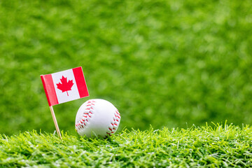 Baseball with flag of Canada on green grass