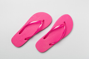 Bright flip flops on color background, top view