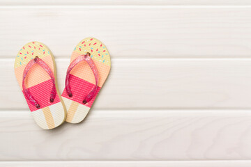 Bright flip flops on wooden background, top view