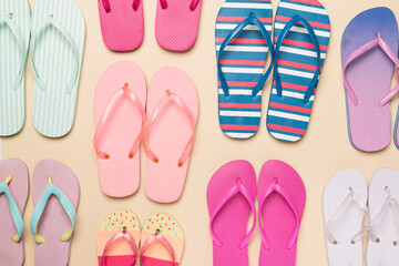 Many colorful flip flops on color background, top view