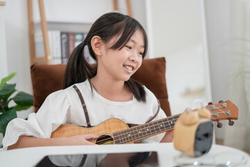 Asian little girl smiling and playing ukulele happiness moment