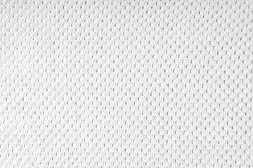 Close up background of knitted wool fabric with dots pattern. White color wool knitwear texture. Openwork abstract knitted jersey. Fabric abstract backdrop