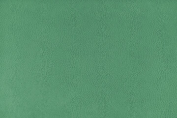 Texture background of green velours fabric textured like leather surface. Fabric texture close up of upholstery furniture textile material, design interior, wall decor, backdrop, wallpaper.