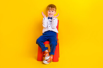 Photo of laughing sweet kid boy sitting kindergarten chair enjoying birthday party surprise isolated shine color background