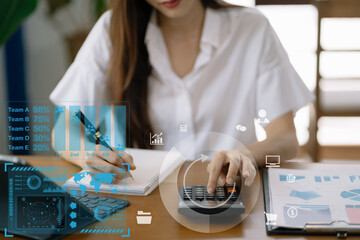 Businesswoman working with tablet and using a calculator to calculate the numbers of static in...