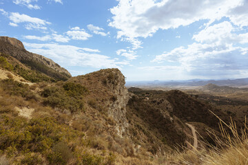 a stone wall with a yellow stone on a mountain grows green grass