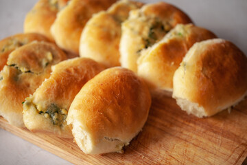 Homemade patties filled with egg and spring onion on a wooden board. Russian cuisine.