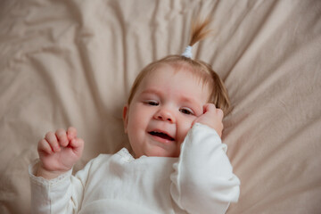 baby girl is lying on her back at home on the bed in the bedroom ,top view