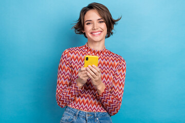 Photo portrait of attractive young woman hold device chatting read news dressed stylish striped clothes isolated on blue color background