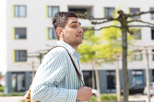 Portrait eines jungen Mannes aussen mit Tasche 
in der Stadt