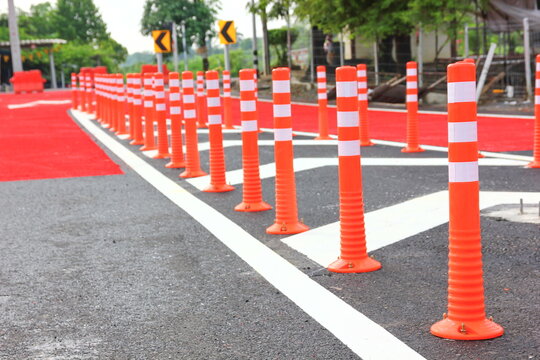 safety delineator with white stripe on plastic pole. traffic safety equiment warning on different road
