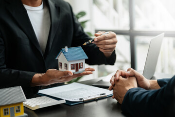 Real estate broker agent presenting and consult to customer to decision making sign insurance form agreement, home model, concerning mortgage loan offer