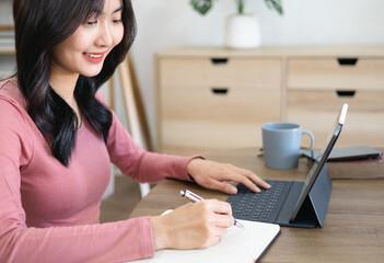 Asian woman  in online learning ,  watching educational webinar on laptop. Young businesswoman...