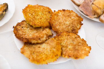 Potato pancakes with sour cream on white plate