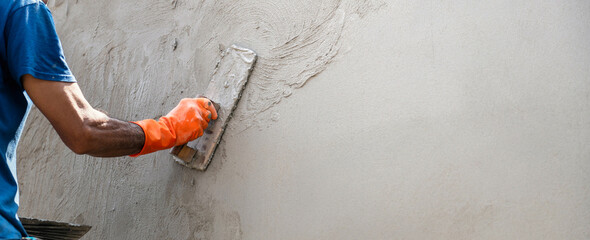closeup hand of worker plastering cement at wall for building house - obrazy, fototapety, plakaty