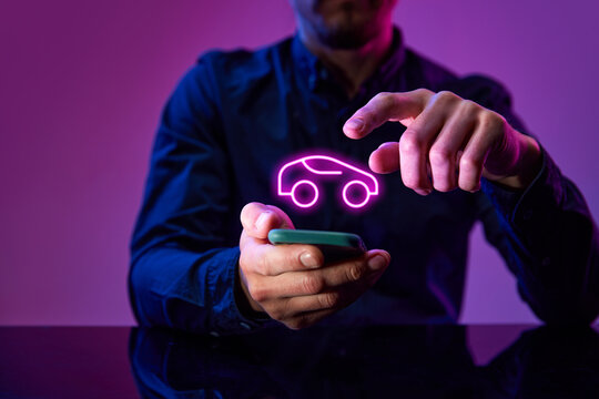 Development of conveniet online shopping and delivery system. Male hand touching neon colored, digital icon of car over mobile phone. Concept of business, modern technologies, network, digitalization
