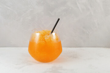 Glass of Orange Granizado or Orange Slushie drink with natural juice. Fruit shaved ice. Refreshing...