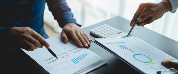 Group of business people meeting about business plans Presenting and explaining financial charts of partners from papers, graphs and data on laptop computer at office.