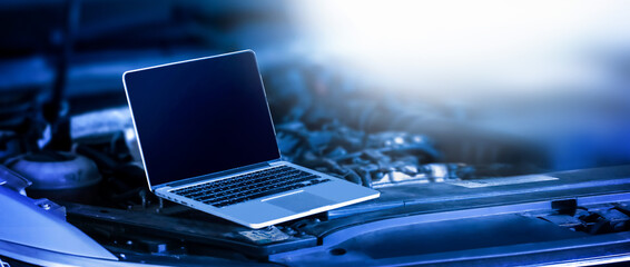 Car diagnostic service close up Mechanic looking into computer. Modern mechanic work in garage. Auto mechanic using computer software for diagnostics engine working and repairing car in a garage.