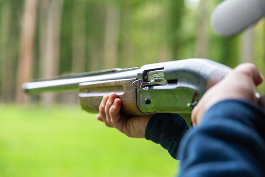 A male shooter aims a sporting double-barreled hunting rifle, target shooting.