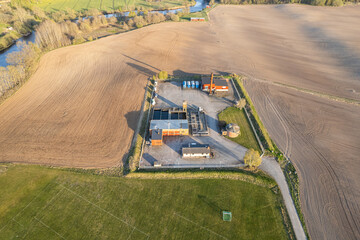 Little factory, production, station in the field. Industry and ecology. People and nature. Agriculture, fields. Aerial view.