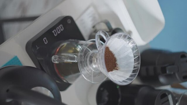 Vertical, fresh coffee grounds in filter of v60 drip brewer on precision scale