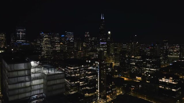 Drone shot over illuminated buildings in downtown Chicago,from the Near West Side