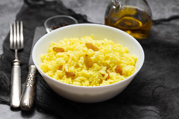 Yellow rice with dried fruit in white bowl