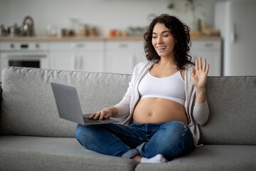 Naklejka premium Online Communication. Smiling Pregnant Woman With Laptop Making Video Call At Home