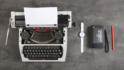 vintage typewriter and tape recorder on the table with blank paper on the desk - concept for writing, journalism, blogging