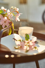Cup of coffee flowers and notebook on the small black table