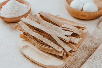 Fototapeta na wymiar Handmade raw pasta pappardelle from whole grain flour on a white table