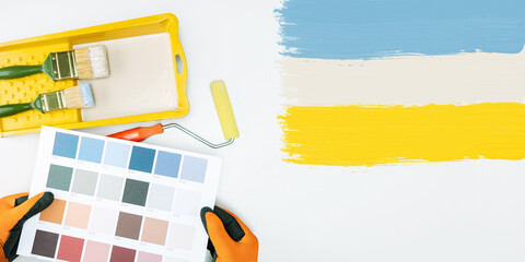 Decorator holding a set of paint colour swatches. Painting and decorating DIY banner.
