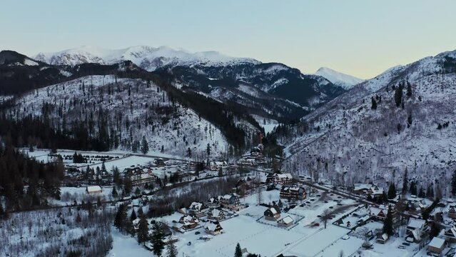 Drone Aerial Beautiful Shot of Snow landscape with traditional Polish houses at sunset - Kościelisko
