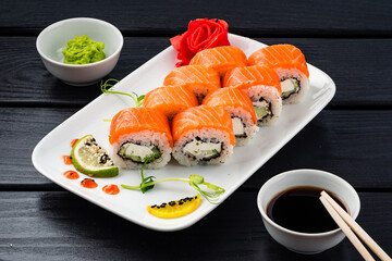Set of sushi rolls Philadelphia with salmon, cream cheese, cucumber, wasabi, ginger and soy sauce.