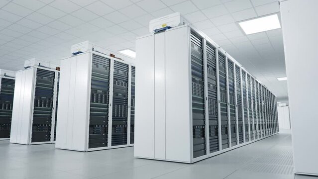  Inside Large Bright and Clean Working Data Center with Rows of White Server Cabinets. Artificial Intelligence Training Cluster. Supercomputer and Advanced Cloud Computing Concept. Loopable Animation.