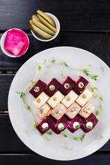 Vinaigrette, Coat, Olivier and mushroom salads in the form of rolls of herring, potatoes, beetroot, bacon, ham, onions, pickled cucumbers and green peas.