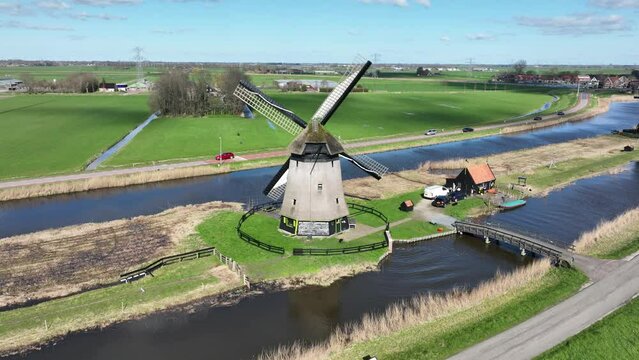The windmill stands tall and proud amidst the serene Dutch polder landscape.